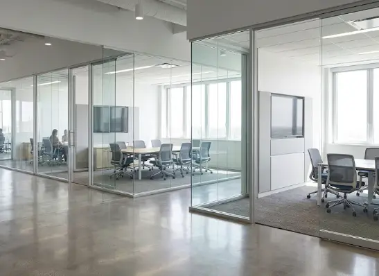 Completed commercial office interior with glass partitions, conference rooms, and modern workspaces